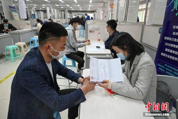 4月14日，招聘者在查看求職者簡歷。<a target='_blank'  data-cke-saved- >中新社</a>記者 王剛 攝